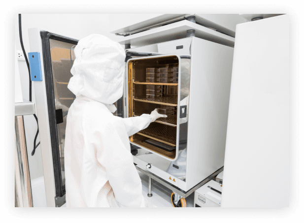 a lab worker placing a tray in a compartment