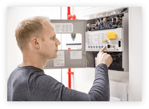 a man interacting with a circuit breaker on the wall