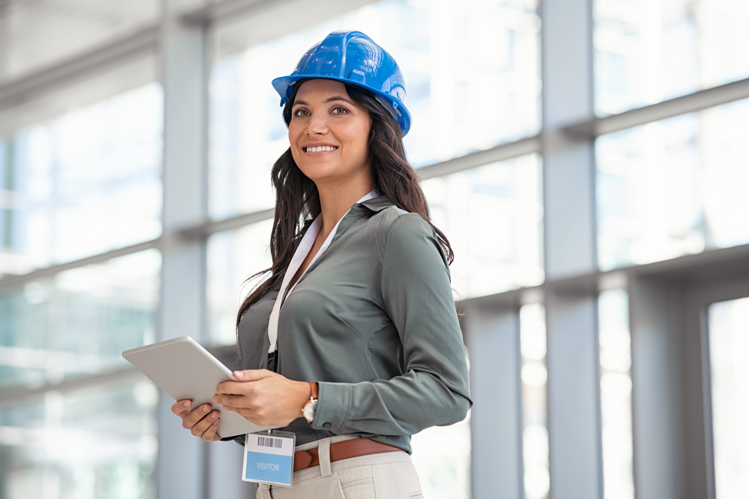 Mid,Adult,Woman,Architect,Wearing,Hardhat,At,Construction,Site,While